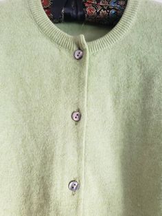 This is a vintage cardigan sweater. It is green, long sleeved and has Mother of Pearl buttons. I do not know its size as there is no label. Please refer to the measurements for a proper fit. I think this sweater is possibly lambswool or angora. I am not sure due to the missing label. Please note, there are 2 or 3 spots that are a bit dark. I dont think these are stains, just little dark marks in the fibers. They are evident in the 4th and 5th pictures. Please feel free to ask to see an image. Th Green Button-up Winter Sweater, Green Button-up Winter Cardigan, Vintage Long Sleeve Cardigan For Layering, Green Crew Neck Winter Cardigan, Vintage Style Long Sleeve Cardigan For Layering, Vintage Green Long Sleeve Cardigan, Green Crew Neck Cardigan For Winter, Green Buttoned Sweater For Layering, Cozy Green Sweater With Buttons