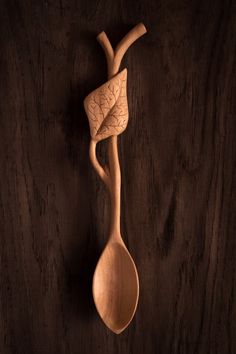 a wooden spoon with a leaf on it