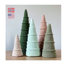 crochet christmas trees are lined up on a table with an american flag in the background