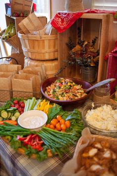 a table topped with lots of different types of food next to boxes and baskets filled with vegetables