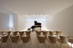 a room filled with lots of chairs and a piano in the middle of it's walls