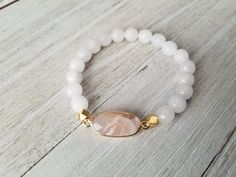 Gorgeous white stack features: -milky white with gold bead and spacers -matte white jade with matte gold hematite and gold spacers -white moonstone paired with a pink moonstone pendant. Pick one or all 3 of them. Choose your bracelet choice and your size from drop box. All your items will be packaged and shipped in a cotton filled kraft box. Adjustable White Crystal Bracelet With Gemstone Beads, White Stretch Bracelet With Faceted Beads For Gift, White Pearl Bracelet With Gemstone Beads For Spiritual Wear, White Spiritual Pearl Bracelet With Gemstone Beads, Spiritual White Pearl Bracelet With Gemstone Beads, Adjustable White Pearl Bracelet With Gemstone Beads, White Spiritual Stretch Bracelet With Gemstone Beads, White Hand-strung Crystal Bracelet, Spiritual White Gemstone Beads Stretch Bracelet