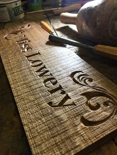 a wooden cutting board with the words twenty five on it and some other woodworking tools