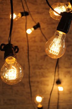 several light bulbs hanging from the ceiling with string lights attached to each bulb and plugged in