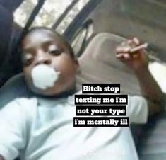 a young boy sitting in the back seat of a car eating something off of his mouth