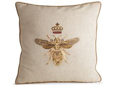 a decorative pillow with a golden bee on it's side and a crown in the middle