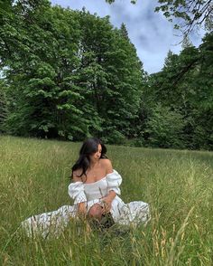 a woman is sitting in the tall grass