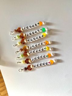 seven small beads are arranged in the shape of jesus's name on a white surface