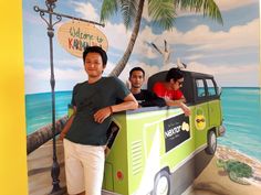 three men standing in front of a green van with a sign that says welcome to key west