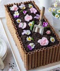 there is a cake with flowers on it and a pipe sticking out of the top