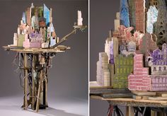 two photographs of an artistic sculpture made out of wood and paper with city buildings on it