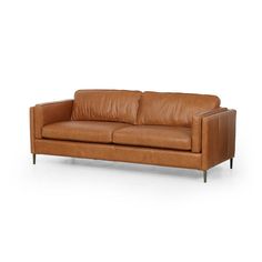 Clean, mid-century styling plus rich butterscotch top-grain leather equals our Livie Sofa. With her tailored lines and slim legs of antique brass she adds laid back luxe vibes to your space.Overall Dimensions: 84.00"w x 36.00"d x 31.50"hColor: rich butterscotchMaterials: Top grain leather.FREE SHIPPINGPLEASE NOTE THIS IS FROM OUR DESIGNER LUXE COLLECTION. PLEASE ALLOW 4-6 WEEKS FOR DELIVERY Simple Home Ideas, New House Living Room, Car Dealerships, Plush Sofa, Lulu And Georgia, Leather Sofas, Leather Couch, Brown Sofa, Simplistic Design