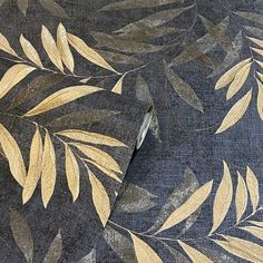 a close up view of a blue and gold fabric with leaves on the back ground