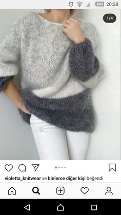 a woman in white jeans and a gray sweater is posing with her hands on her hips