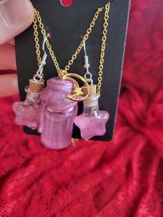 Add a touch of enchantment to your style with this charming Magic Shimmer Potion Bottle Necklace and Earring Set! This whimsical pendant features a miniature glass bottle filled with sparkling shimmer potion, capturing the essence of magic and mystery. The glass bottle is securely sealed and suspended from a dainty chain, perfect for adding a hint of mystical allure to any outfit. Whether you're a lover of fantasy or simply appreciate unique jewelry, this set is sure to bring a touch of magic to your day. Perfect for cosplay or ren faire accesories! ONE OF A KIND PIECE PLEASE NOTE I MAY NOT BE ABLE TO RECREATE THIS SPECIFIC COLOR! (If You Love it.. Get it now!) ;) Each necklace set is a handmade treasure and  truly ONE OF A KIND!  Chains (22.5" long) with easy to use clasps. 925 Sterling S Whimsical Purple Jewelry For Gifts, Pink Spiritual Charm Necklace For Gift, Spiritual Pink Charm Necklace As Gift, Spiritual Pink Charm Necklace For Gift, Mystical Dangle Jewelry For Gifts, Handmade Magical Charm Necklaces For Gifts, Potion Bottle Earrings, Handmade Magical Jewelry For Gifts, Handmade Magical Jewelry As A Gift