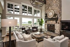 a living room filled with furniture and a fire place in front of a large window