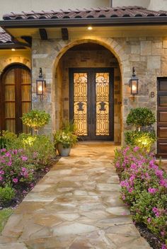 the front entrance to a house with flowers and plants