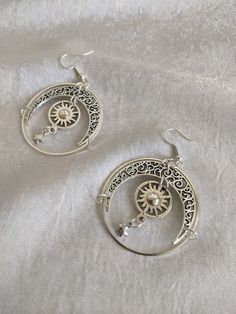 These gorgeous drop earrings feature filigree moons, suns, and star charms enclosed in a celestial circle. Perfect piece for a little everyday magic! Choose between silver or bronze Festival Moon Charm Jewelry, Festival Jewelry With Moon Charm, Celestial Sun And Moon Dangle Jewelry, Celestial Star Jewelry For Festival, Celestial Style Silver Metal Jewelry, Celestial Star-shaped Festival Jewelry, Celestial Festival Star Jewelry, Nickel Free Moon Shaped Jewelry For Festival, Silver Moon Bohemian Jewelry