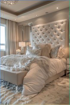 a large white bed sitting in a bedroom next to a window with curtains on it