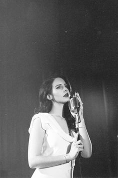 a woman in white dress holding a microphone