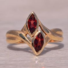 This Stunning Piece, Known As The Double Garnet, Features Two Captivating Marquise Cut Garnets, Each Bezel Set In A Beautiful 14 Karat Yellow Gold Band. The Design Is Both Elegant And Unique, Making It A Perfect Statement Piece For Any Jewelry Collection. This Exquisite Ring Is Currently A Finger Size 6 Yet Can Be Adjusted To Any Finger Size For An Additional Charge Upon Request, Ensuring A Perfect Fit. Enchanted Jewelry, Yellow Gold Color, Garnet Ring, Jewelry Photography, Garnet Rings, Marquise Cut, Gold Band, Bezel Setting, Womens Jewelry Rings