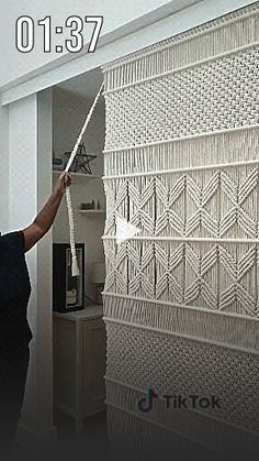 a man is painting the wall in his living room with white paint and stringing