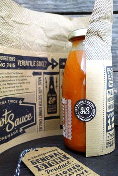 a bottle of hot sauce sitting on top of a table next to some paper bags