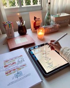 a person sitting at a desk writing on a tablet