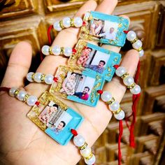 three small frames are held in the palm of someone's hand with pearls on them