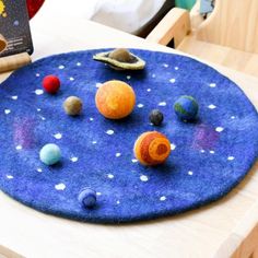 a child's play mat with planets on it and a book in the background