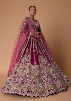 a woman in a pink and gold lehenga