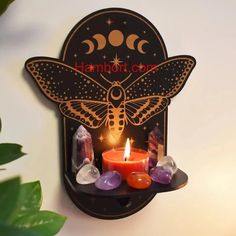 a candle is lit in the shape of a butterfly with stars and moon on it