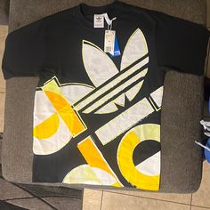 Adidas Casual Athletic Tee New With Tags Yellow Urban T-shirt For Streetwear, Urban Yellow T-shirt With Letter Print, Yellow Graphic T-shirt With Crew Neck, Yellow Sporty T-shirt With Letter Print, Streetwear Yellow Top With Graphic Design, Yellow Graphic Design Top For Streetwear, Sporty Yellow T-shirt With Text Print, Urban Style Yellow Tops With Graphic Print, Urban Style Yellow Graphic Print Tops