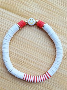 a red and white bracelet with a smiley face on it