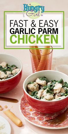 two red bowls filled with chicken and spinach on top of a pink table cloth