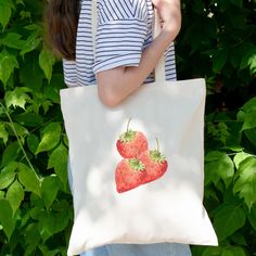 Are you looking for a strawberry tote bag for friends and family? Then this cute tote bag with strawberry design good be a nice gift for them for their birthday. Surprise a garden or fruit lover with this cottagecore inspired tote bag in the spring. Tote bag. Cover all your grab and go needs with these long handle tote bags while being eco-conscious. These tote bags feature reinforced stitching on handles for more stability. Your unique designs will stand out on these 100% cotton fabric tote bags.  - Reinforced stitching on handles - Capacity 10 litres - 100% cotton - 3 - 5  oz/yard², 100 - 170  g/m² Your order: *Before paying the order please check the colour of the tote bag you want *Check the address where the product will be send to *If you have any questions, please ask them before yo Red Bag With Strawberry Print As Gift, Rectangular Bag With Strawberry Print As Gift, Rectangular Bags With Strawberry Print As Gift, Rectangular Strawberry Print Bag As A Gift, Rectangular Bags With Strawberry Print For Gifts, Rectangular Strawberry Print Bag For Gifts, Casual Rectangular Bag With Strawberry Print, Summer Strawberry Print Bag For Daily Use, Summer Strawberry Print Bags For Daily Use