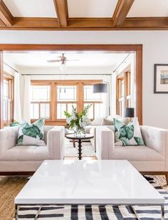 a living room with two couches and a coffee table in front of a window