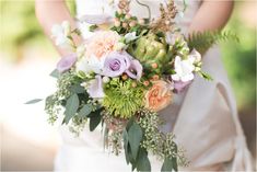 a bride holding a bouquet of flowers in her hands