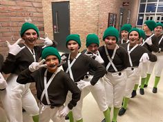 a group of young people dressed in green and white outfits standing next to each other