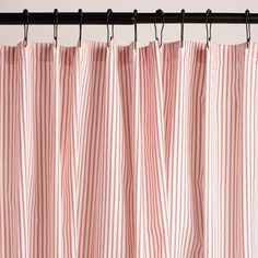 a red and white striped curtain hanging from a metal rod with black hardware on it