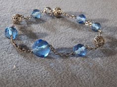 We are offering you this very stylish and truly stunning vintage silver tone blue crystal beads and fancy filigree beads chain bracelet. There are so many exciting design elements to this gorgeous piece! The bracelet features varying sizes of faceted blue crystal round beads alternating with silver tone chain links and fancy silver tone filigree round beads, it is magnificent! This is a must have item for the serious vintage jewelry collector! The impressive bracelet measures approx. 7 inches in Elegant Blue Crystal Bracelet With Silver Beads, Elegant Blue Crystal Metal Bracelet, Elegant Blue Metal Beaded Bracelets, Elegant Blue Beaded Metal Bracelets, Blue Crystal Beads, Beads Chain, Chain Links, Blue Crystals, Beaded Chain