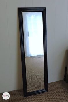 a mirror sitting on the floor in front of a wall