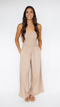 Stand out in this stunning Khush Clothing jumpsuit, made to flow with buttery soft rayon and an exaggerated wide pant leg. Features adjustable straps and a gentle smocked waist to flatter. ** Our Model is 5'8" and wearing a size SMALL. ** Fabric and Care Instructions: *100% Rayon *Hand wash cold *Line Dry Summer Beige Jumpsuits And Rompers With Elastic Waistband, Wide Leg Jumpsuit For Beach, Summer Wide Leg Jumpsuits And Rompers With Elastic Waistband, Summer Wide-leg Jumpsuits And Rompers With Elastic Waistband, Summer Wide Leg Jumpsuits With Elastic Waistband, Spring Strapless Jumpsuit With Elastic Waistband For Loungewear, Beige Jumpsuits And Rompers With Elastic Waistband For Spring, Solid Color Wide Leg Jumpsuits With Elastic Waistband, Sleeveless Rayon Jumpsuits And Rompers For Spring