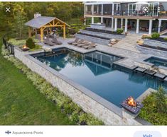 an aerial view of a backyard with a pool and fire pit in the foreground