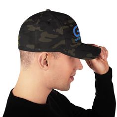 a man wearing a camo hat with the g on it's front and side