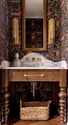 a bathroom with a sink, mirror and basket on the floor in front of it