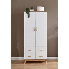 a white cabinet with two drawers and a potted plant sitting on top of it