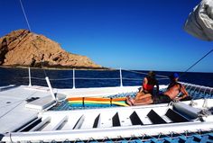 two people sitting on the back of a boat