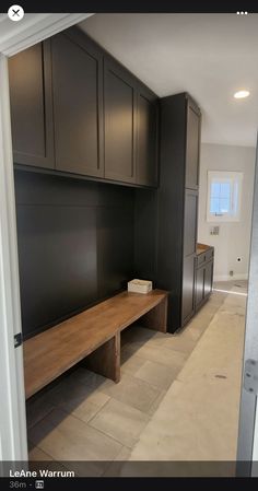 an empty room with black cabinets and a wooden bench