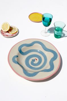 a blue and white plate sitting on top of a table next to two glasses filled with liquid